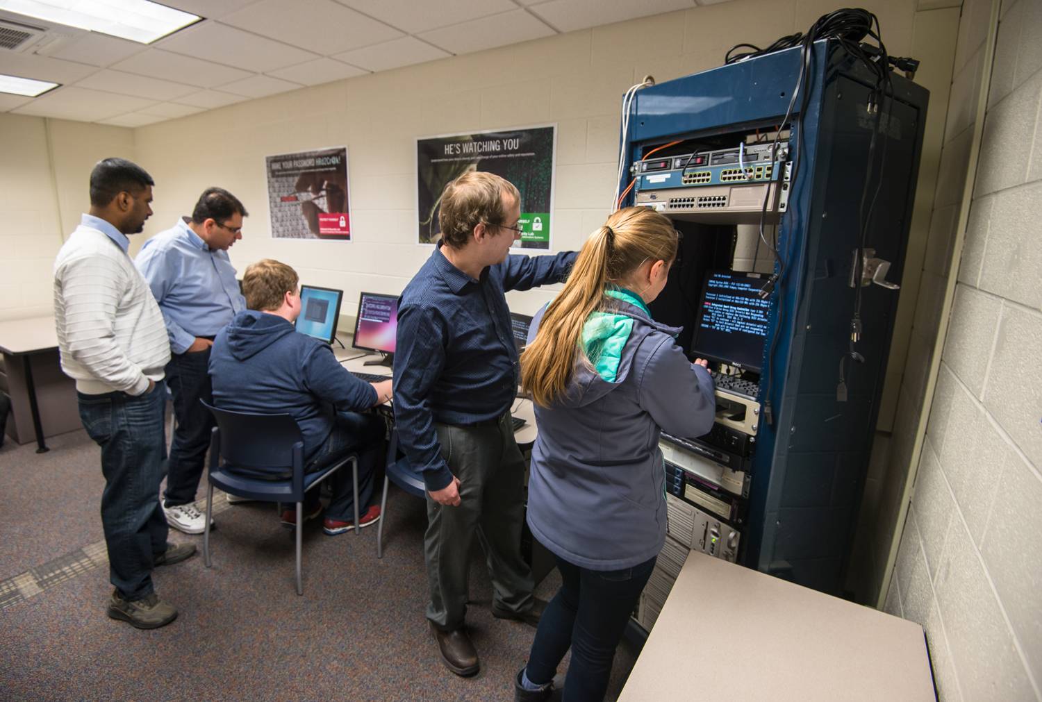 Faculty and students working on cyber equipment